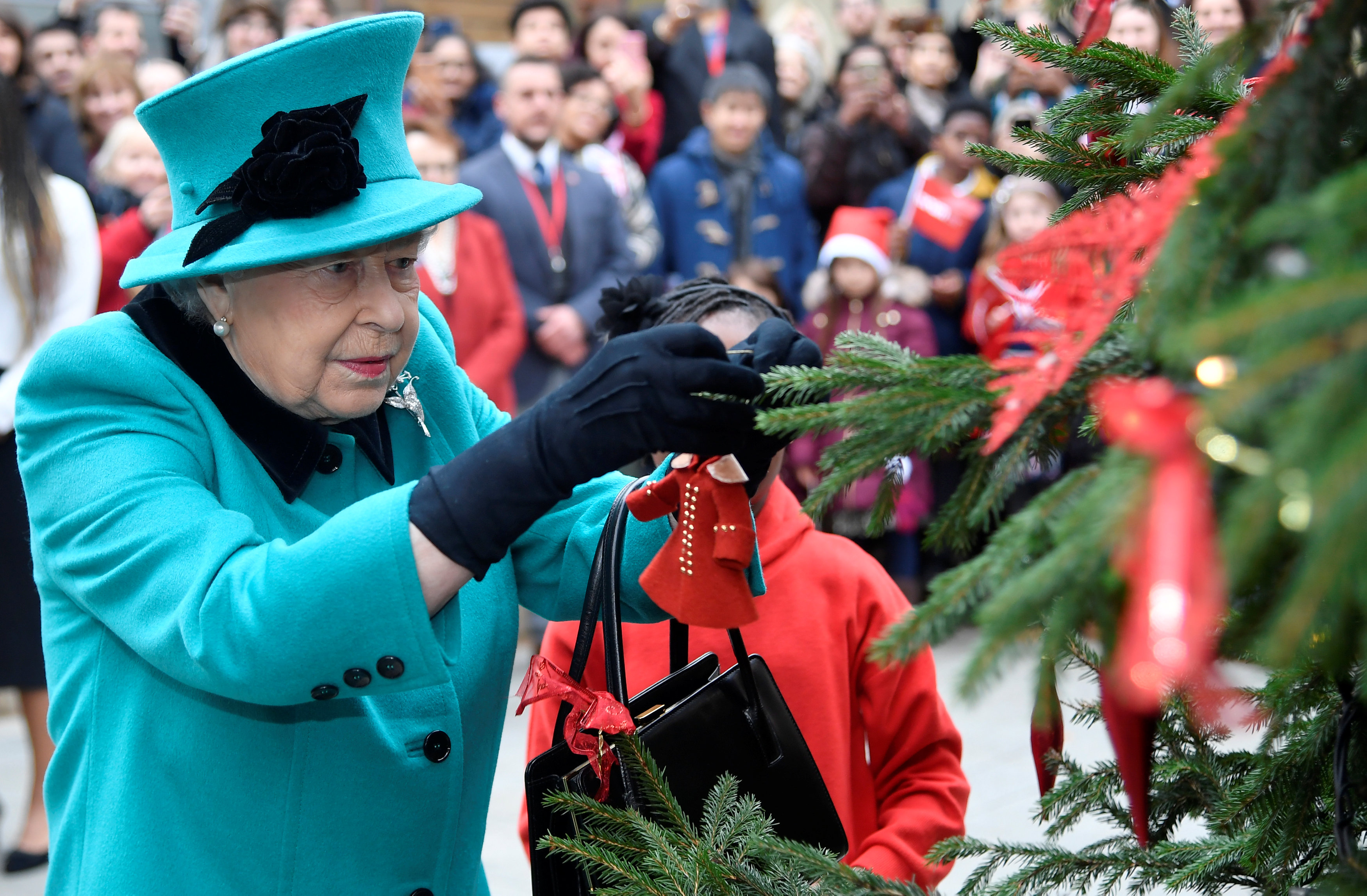 Королева Елизавета II, 2018 LONDON, ENGLAND - DECEMBER 05: Queen Elizabeth II and Shylah Gordon, aged 8, attach a bauble to a Christmas tree during the opening of the Queen Elizabeth II centre at CORAM on December 05, 2018 in London, England. (Photo by )