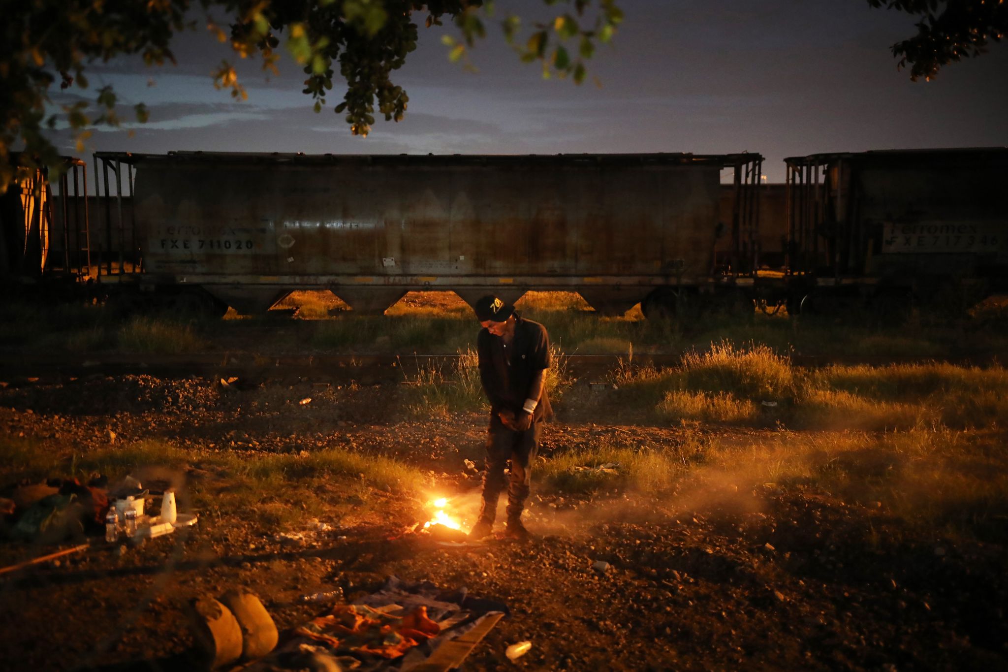 Наркоман греется у костра на пустыре рядом с храмом Мальверде A drug addict warms himself at a trash fire, in the waste ground next to the Malverde shrine