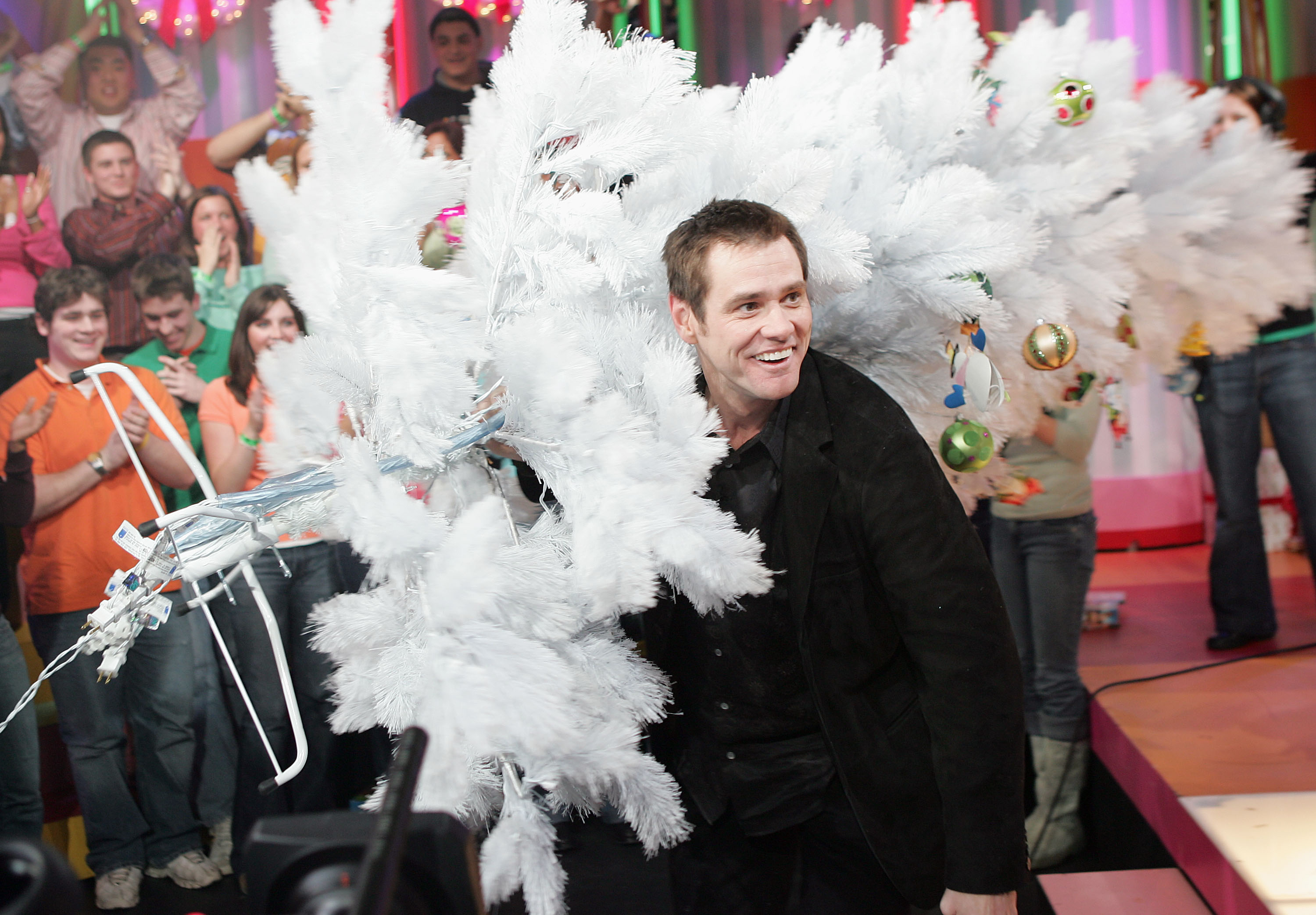 Джим Керри идет на шоу MTV's Total Request Live, 2004 NEW YORK - DECEMBER 13: (US TABS OUT) Actor/Comedian Jim Carrey holds a white Christmas tree as he appears on stage during MTV's Total Request Live at the MTV Times Square Studios December 13, 2004 in New York City. (Photo by )