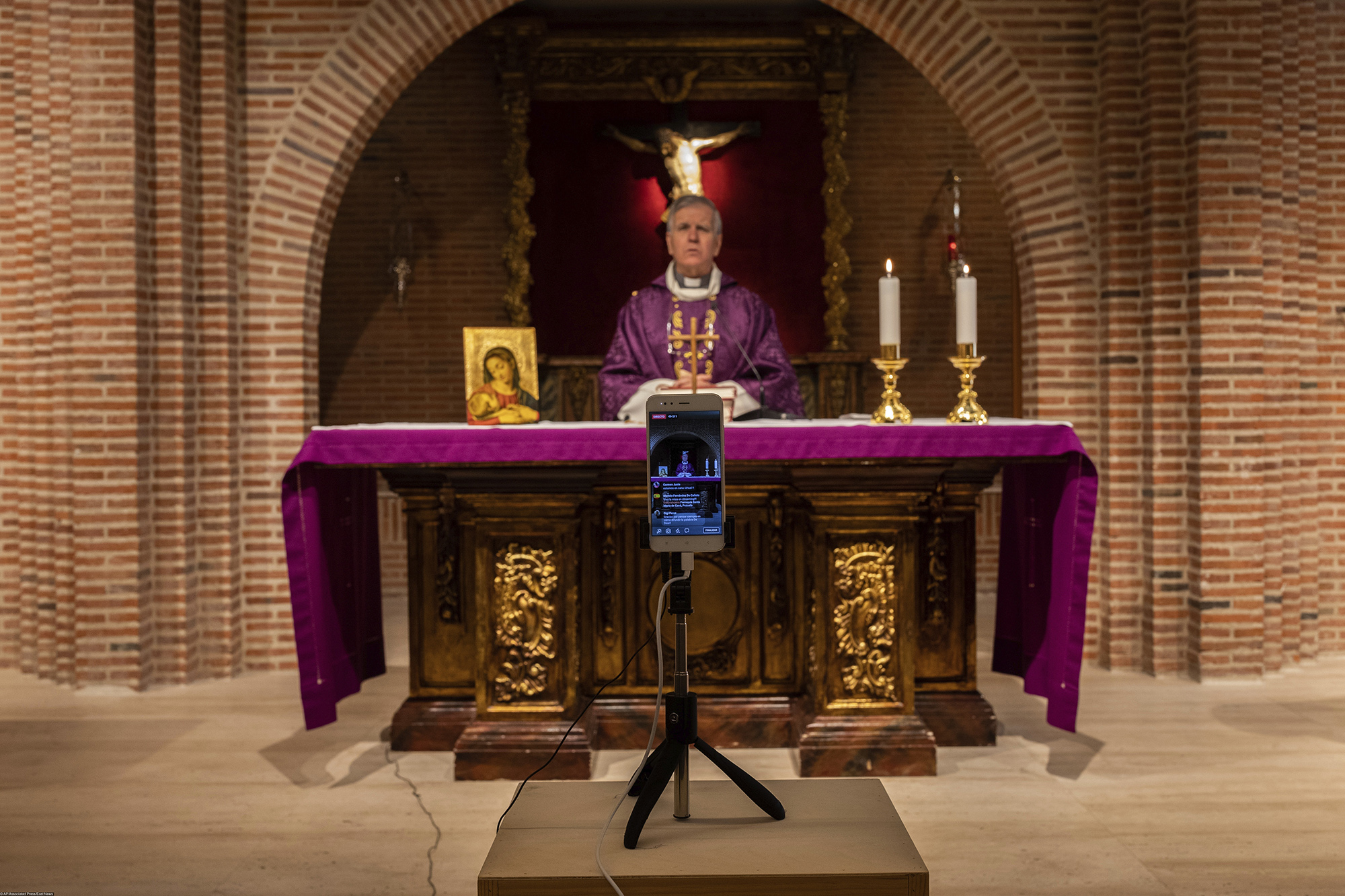 Обращение священника по видеосвязи в Мадриде, Испания Catholic priest Catholic priest Jesus Higueras from the Santa Maria de Cana parish is seen on a smartphone during a live video streamed mass in Pozuelo de Alarcon, outskirts Madrid, Spain, Sunday, March 15, 2020. Pope Francis has praised people for their continuing efforts to help vulnerable communities, including the poor and the homeless, amid the coronavirus pandemic. The vast majority of people recover from the COVID-19. According to the World Health Organization, most people recover in about two to six weeks, depending on the severity of the illness. (AP Photo/Bernat Armangue)