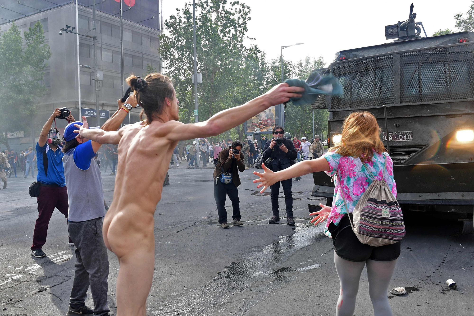 Беспорядки в Сантьяго Demonstrators clash with riot police in Santiago, on October 19, 2019. - Chile's president declared a state of emergency in Santiago Friday night and gave the military responsibility for security after a day of violent protests over an increase in the price of metro tickets.