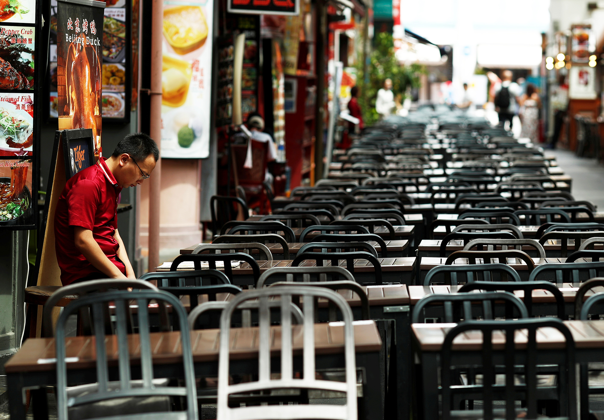 Пустой Чайна-таун в Сингапуре, 21 февраля A restaurant promoter waits for customers at the largely empty Chinatown as tourism takes a decline due to the coronavirus outbreak in Singapore February 21, 2020. Picture taken February 21, 2020. REUTERS/Edgar Su