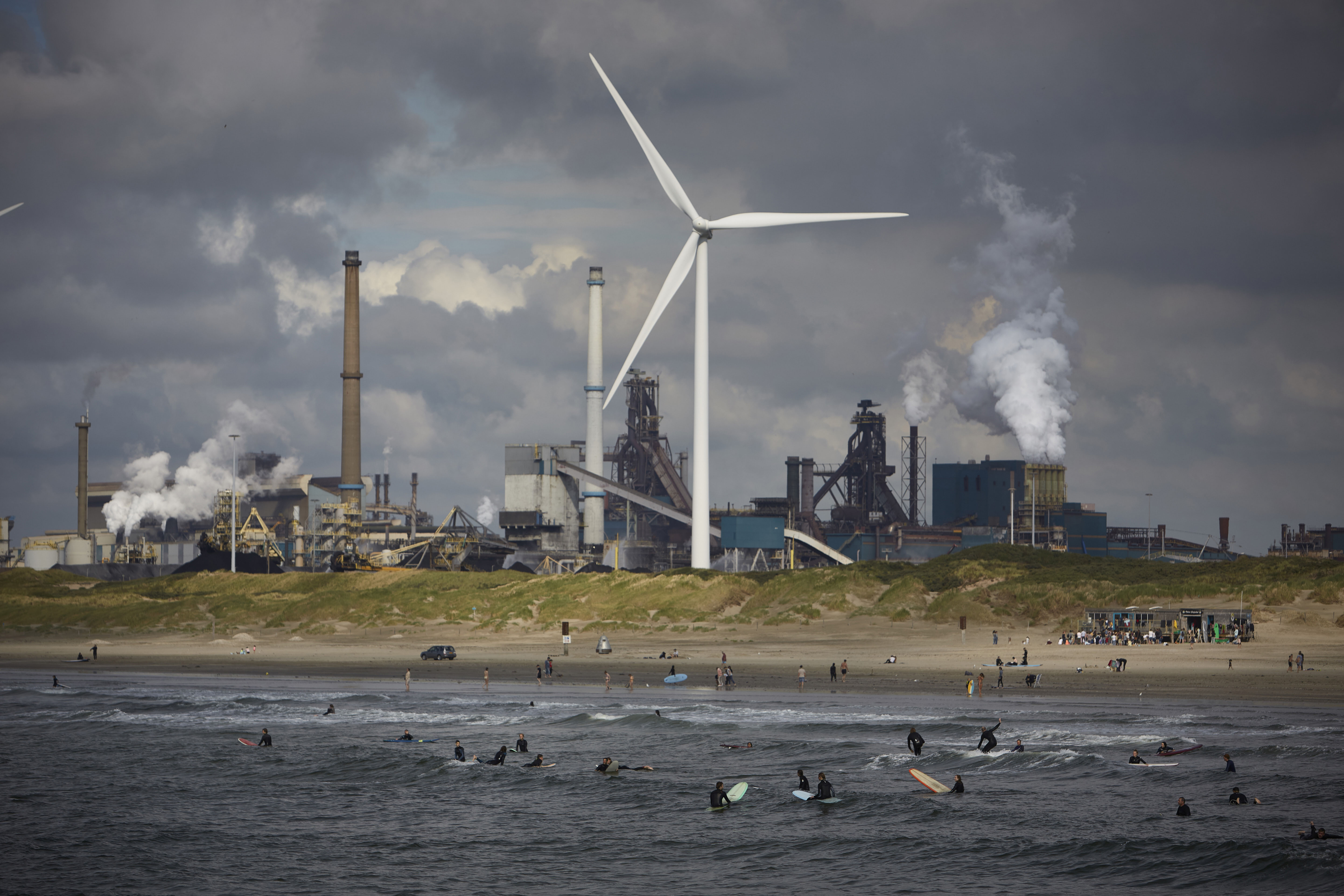 Серферы на фоне сталелитейного Tata Steel, угрожающего окружающей среде, Велзен-Норд, Нидерланды, 20 августа 2021 года. Серферы на фоне сталелитейного Tata Steel, угрожающего окружающей среде, пирса 20 августа 2021 года в Велсен-Ноорде. Сталелитейный завод Tata находится под следствием голландской