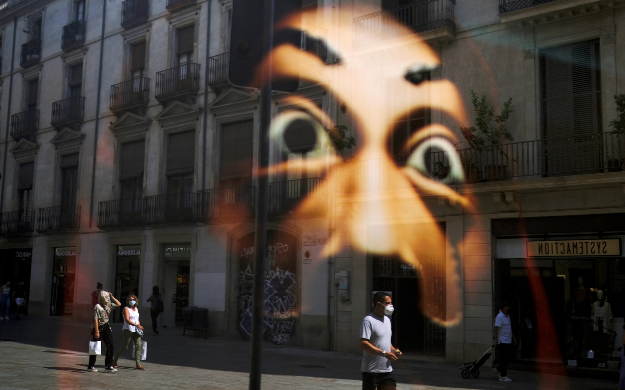 Готический квартал Барселоны DOCUMENT DATE:September 15, 2020People wearing face masks are reflected in a window of a shop as they walk on a street at Barrio Gotico (Gothic Quarter), after Catalonia's regional authorities announced restrictions to contain the spread of the coronavirus disease (COVID-19), in Barcelona, Spain September 15, 2020. REUTERS/Nacho Doce