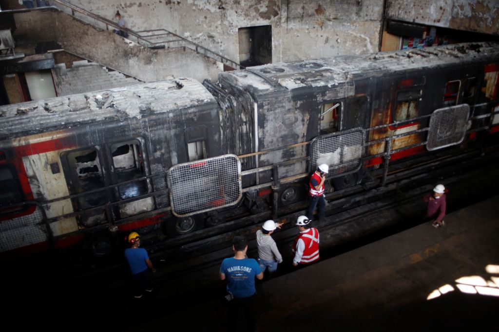 Сгоревший поезд в метро города Сантьяго Locals help in cleaning of the Metro of Santiago subway at Station San Pablo