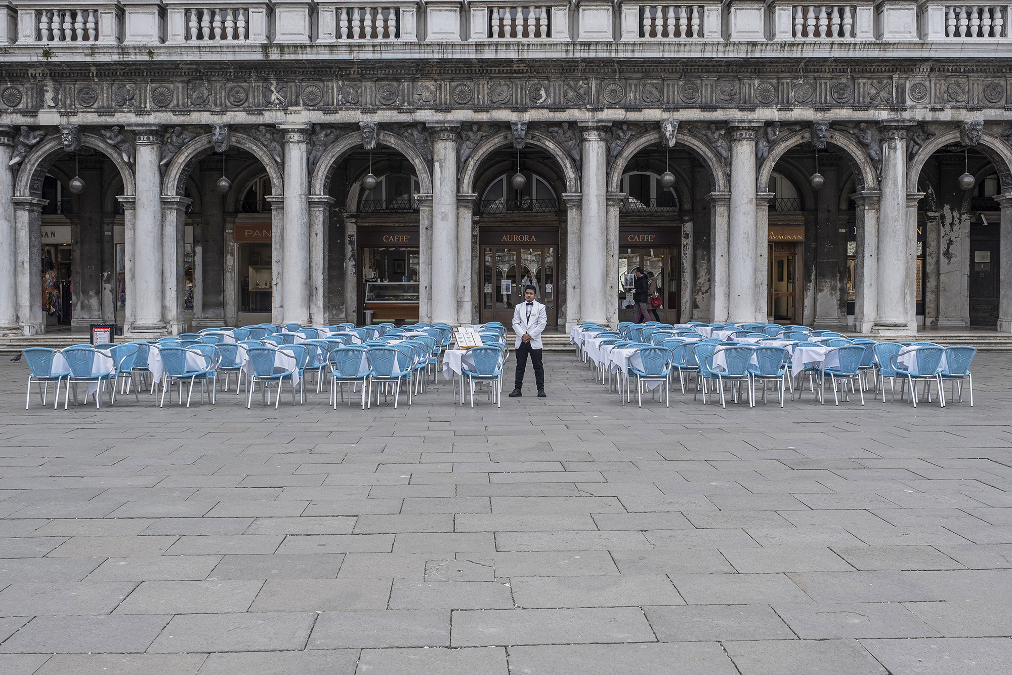 Официант стоит возле абсолютно пустого кафе в Венеции, 6 марта ENICE, ITALY - MARCH 06: A waiter stands in the deserted Piazza San Marco on March 06, 2020 in Venice, Italy. Venice is deserted because of COVID-19, yesterday, March 5, a third person died in the city due to the COVID-19 virus. The latest Civil Protection bulletin talks about 3,858 COVID-19 positives, 148 people died and 414 have recovered in Italy. (Photo by Stefano Mazzola/Awakening/Getty Images)