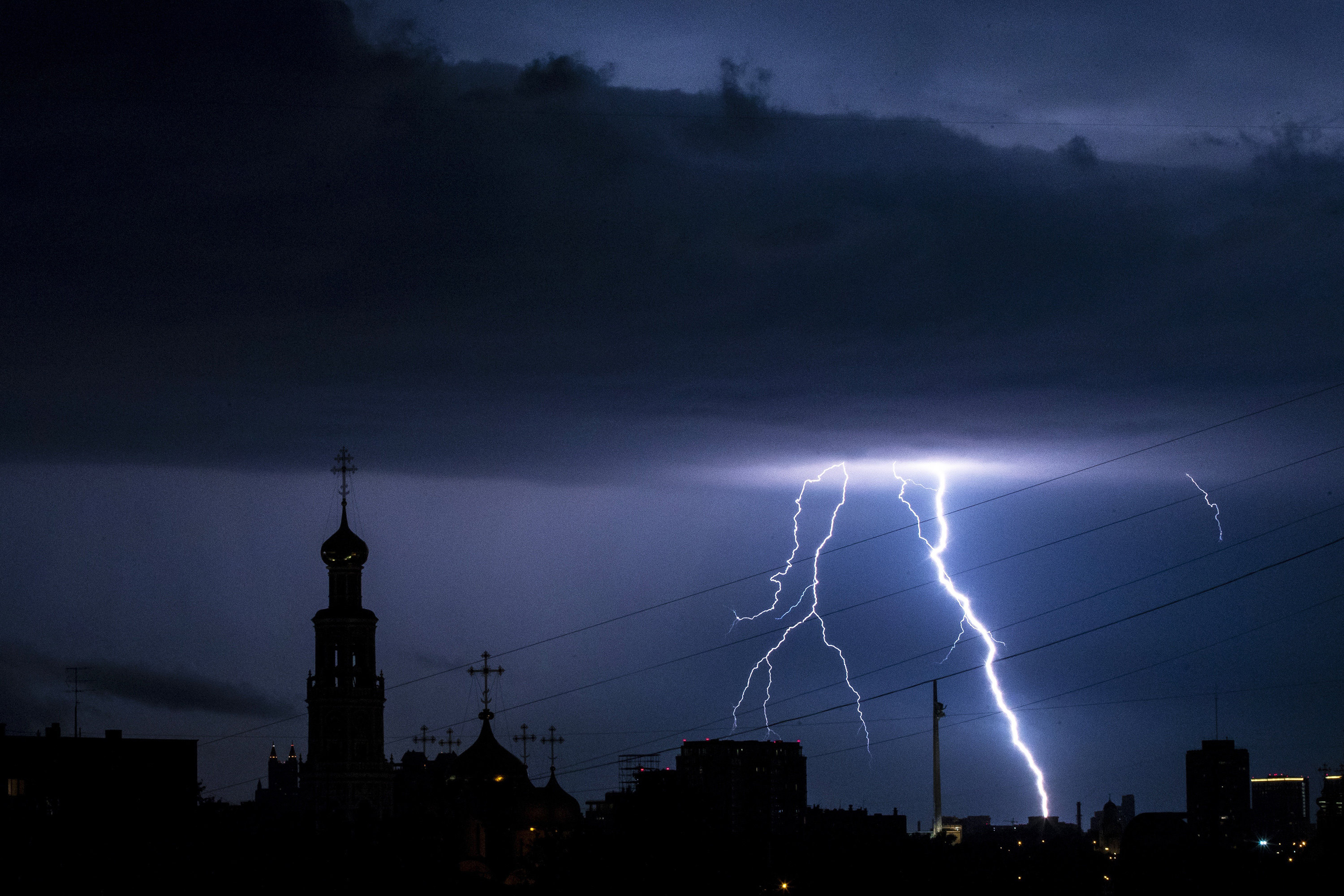 Новодевичий монастырь в Москве в свете молний Lightning strikes over the Poklonnaya Hill, and lights the Novodevichy Convent, left, in Moscow, Russia, late Tuesday, July 7, 2020. The hot weather in Moscow is continuing, with temperatures forecast to reach over 30 degrees Celsius (86 Fahrenheit). (AP Photo/)