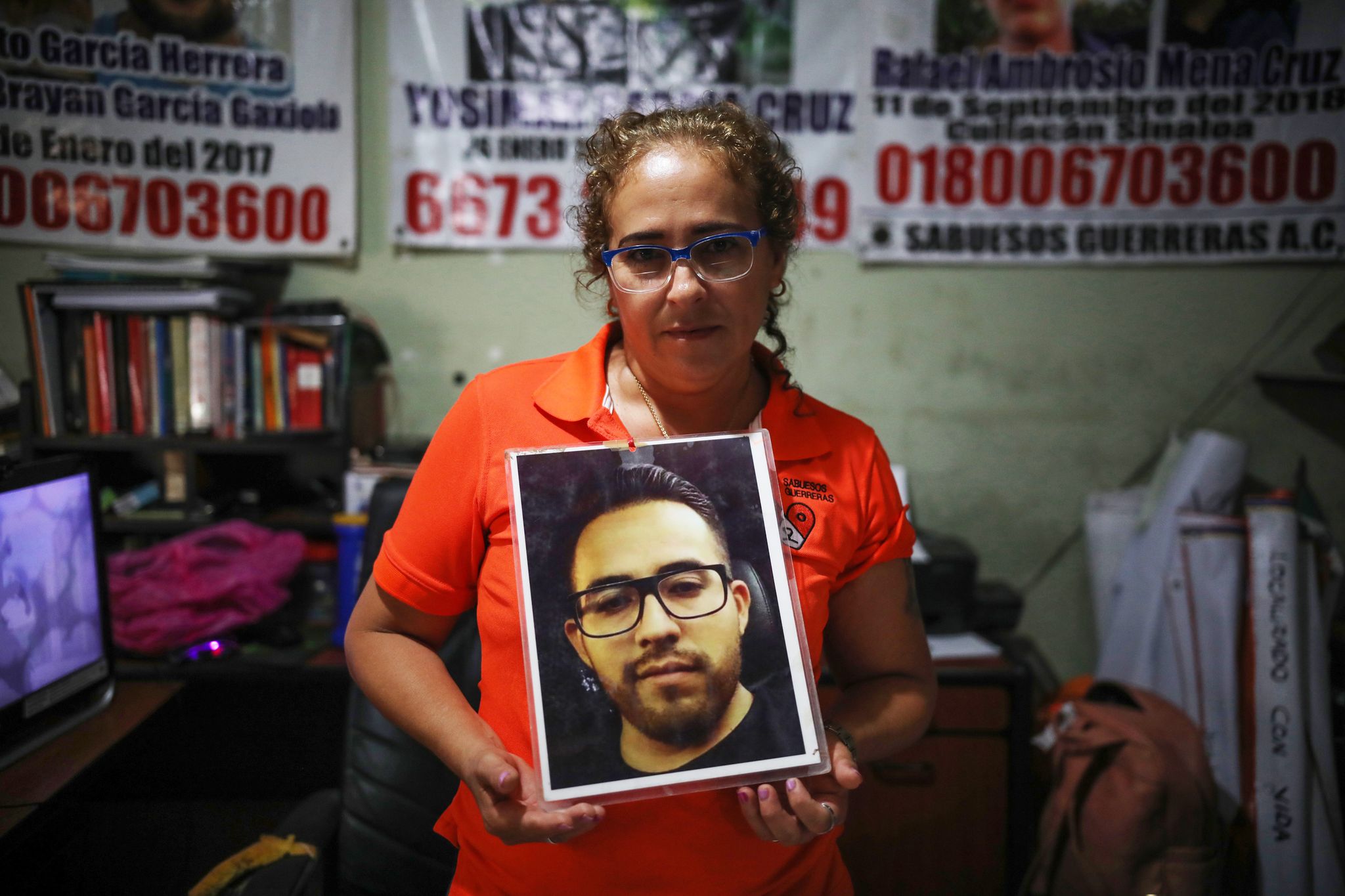 Мария Изабель Круз Берналь с портретом сына Maria Isabel Cruz Bernal, founder of Sabuesos Guerros, holds up a photo of her son, Yosimar Garcia, who has been missing for several years.